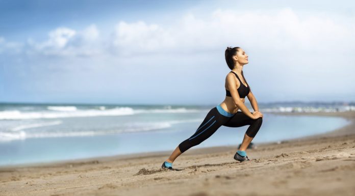 Deportista haciendo estiramiento en la playa